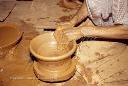 Image du Maroc Professionnelle de  Comme Safi est le chef-lieu de la poterie céramique marocaine, c’est à l’intérieur de son atelier que l’artisan tourneur travaille l'argile brute puis le transforme ainsi dans sa forme, souvent il s'agit d'objets de forme essentielle destinés à l'usage domestique. Quand l’objet est façonné selon le besoin une petit lame est utilisé pour donner à l'objet un aspect lisse. Souvent les artisans ont recours à leur dextérité afin de fignoler la décoration à Safi Vendredi 29 Août 1997.(Photo / Abdeljalil Bounhar) 